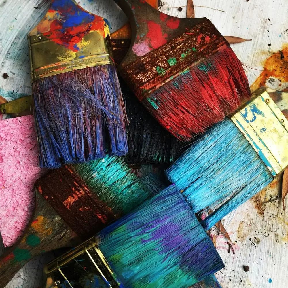 Paintbrushes loaded with bright colour on a studio table